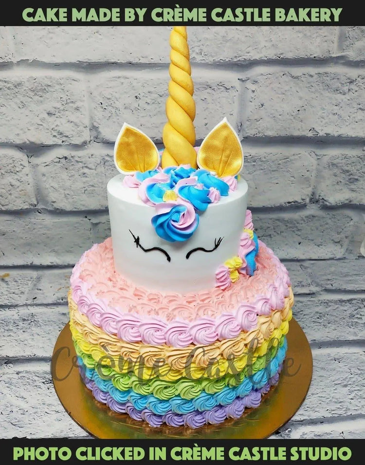 A tier cake in unicorn theme with rainbow in bottom tier made with ...