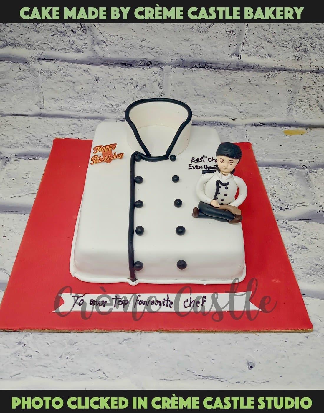 Happy cook decorates a cake. Pastry-cook in chef uniform and cap at work.  Male confectioner